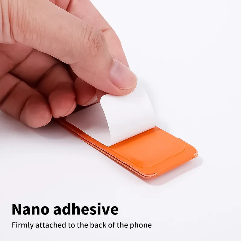 A close-up of a hand peeling off a white protective adhesive film from an orange phone accessory, with text at the bottom reading 'Nano adhesive' and 'Firmly attached to the back of the phone' on a white background.
