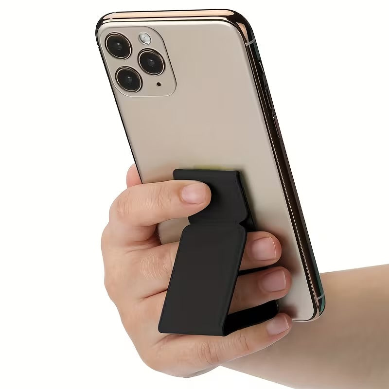 A hand holding a smartphone with a black magnetic kickstand attached to the back, shown against a plain white background.